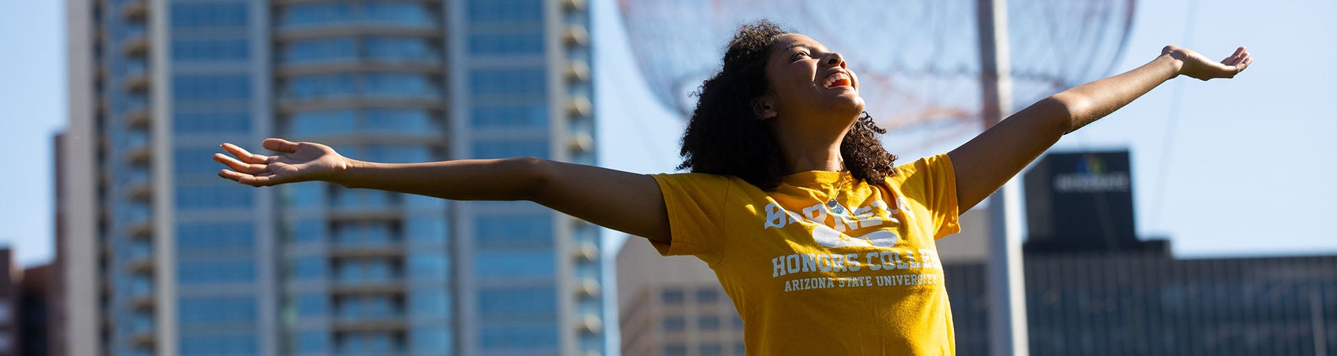 Female Barrett student raising both hands to express triumphant happiness