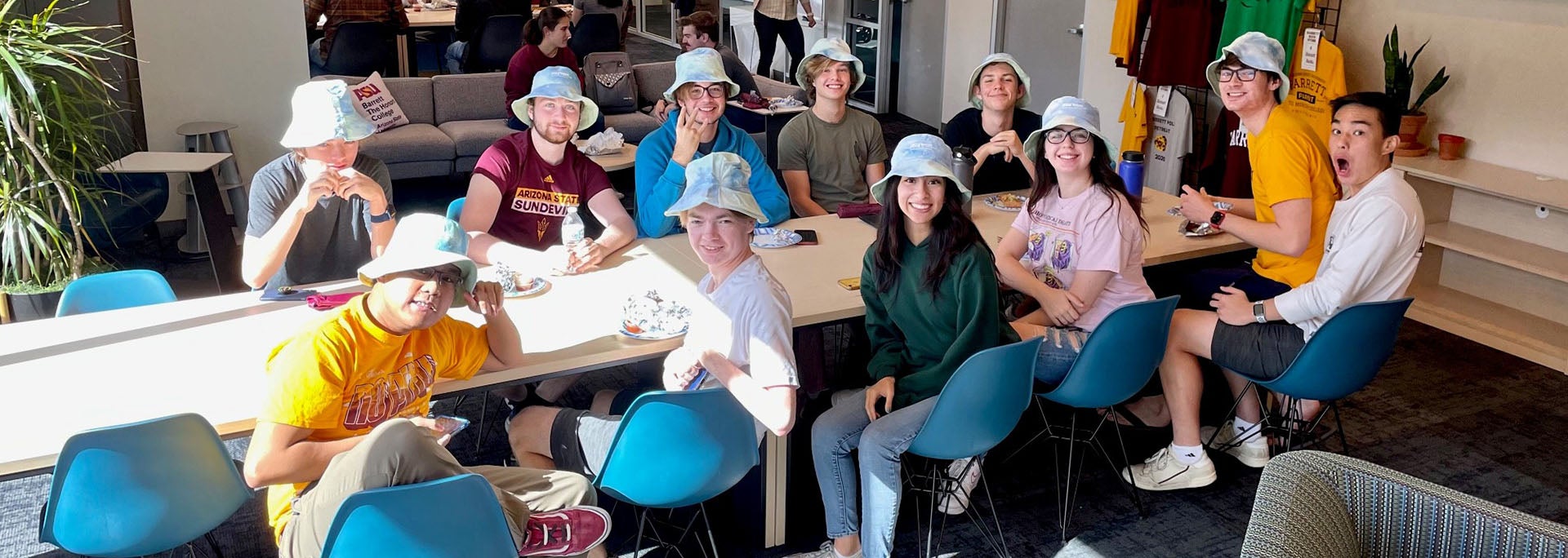 Many students gathered around the Barrett Poly suite wearing identical hats and smiling
