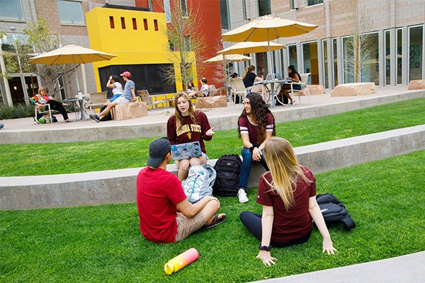 Four Barrett students sitting on the great lawn outside the Barrett Tempe campus