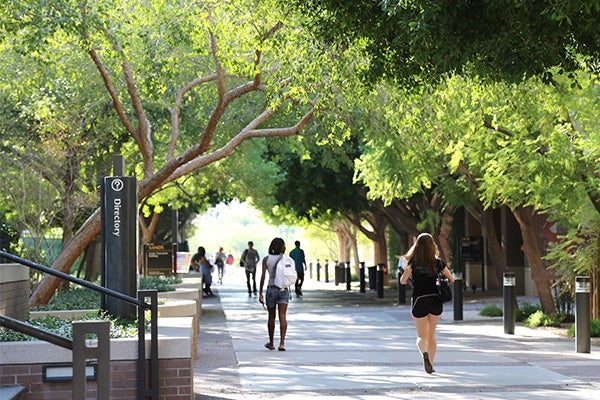 Many students walking down a main path on the Barrett West campus during the daytime