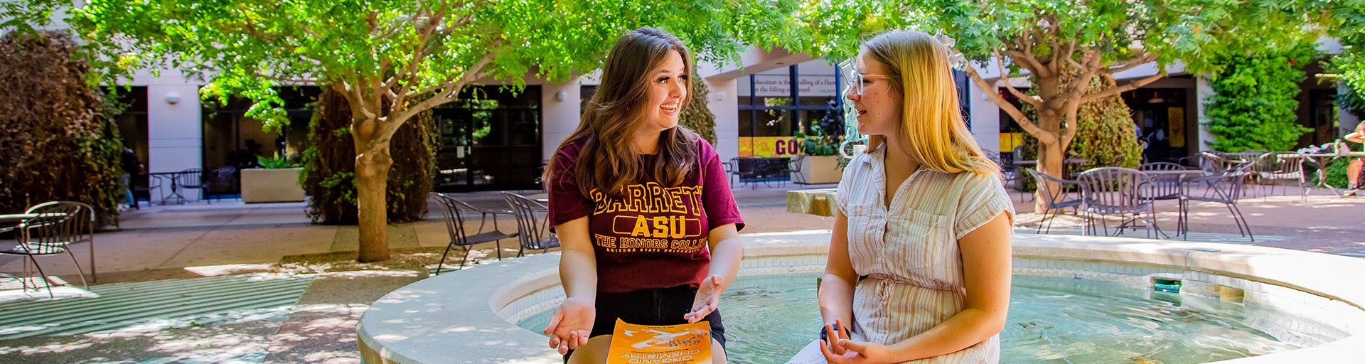 Two Barrett students having a conversation by a fountain