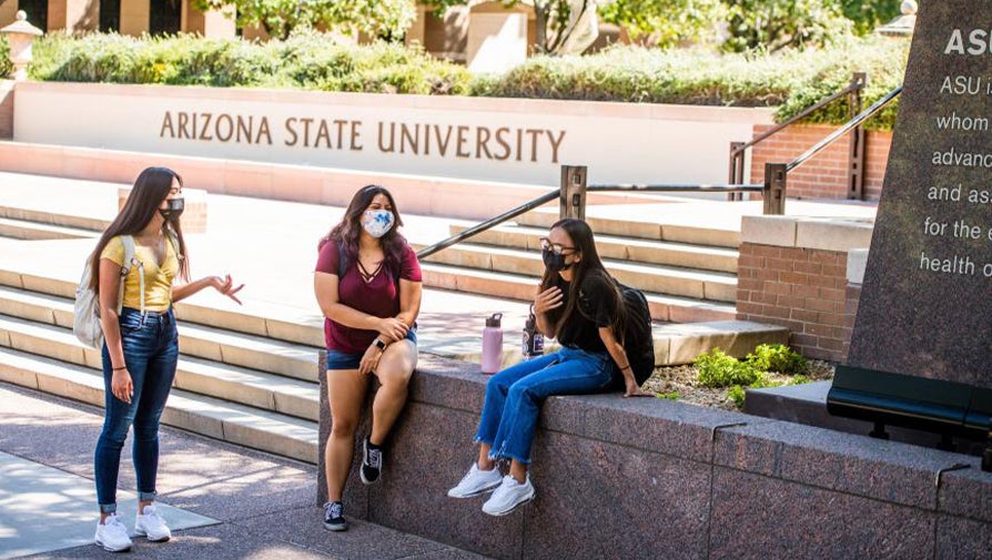 Several ASU students talking on the stairs in front of the ASU Charter
