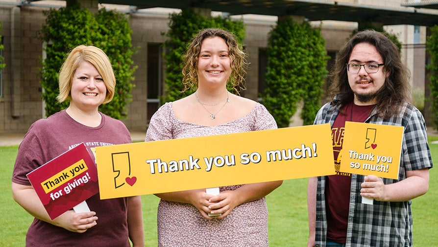Three Barrett students holding thank you cards on the Barrett Tempe campus