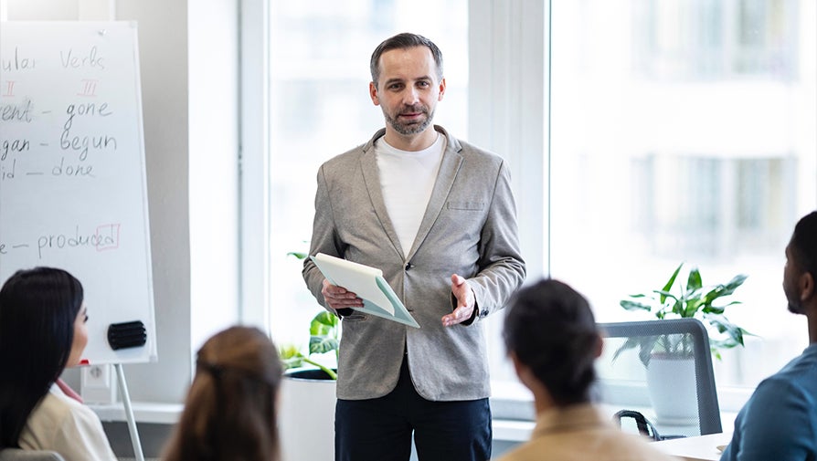 Man wearing professional attire presenting to a group of people