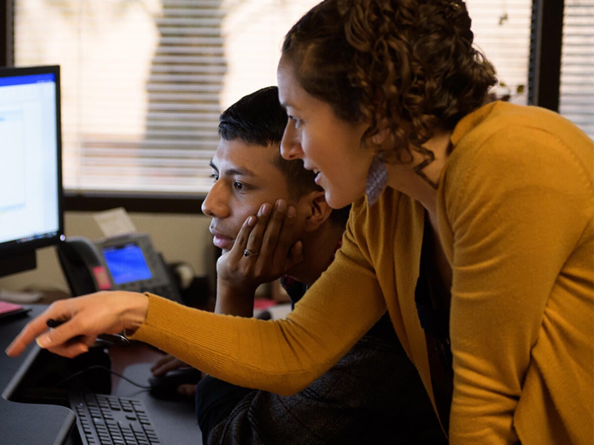 Adult helping a student at the computer