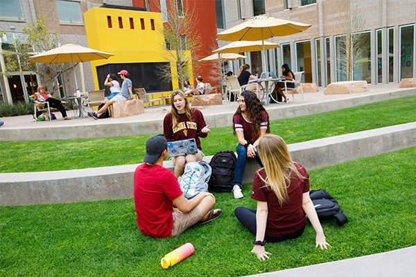 Four Barrett students sitting on the great lawn outside the Barrett Tempe campus