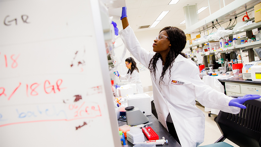 Individual wearing a lab coat working in a lab